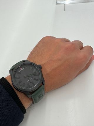 Reloj elegante negro con correa verde – estilo mod