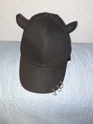 Gorra negra con cuernos y anillos