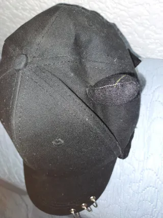 Gorra negra con cuernos y anillos