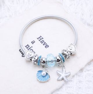 Pulsera de acero con charms preciosos