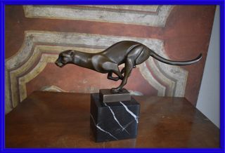 Figura de bronce de una pantera corriendo sobre ba