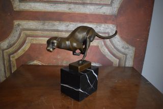 Figura de bronce de una pantera corriendo sobre ba