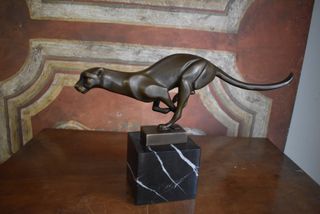 Figura de bronce de una pantera corriendo sobre ba