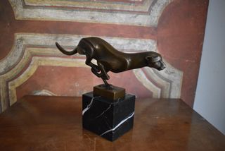 Figura de bronce de una pantera corriendo sobre ba