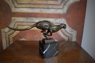 Figura de bronce de una pantera corriendo sobre ba