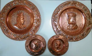 Set di quattro piatti decorativi in rame con rilievi