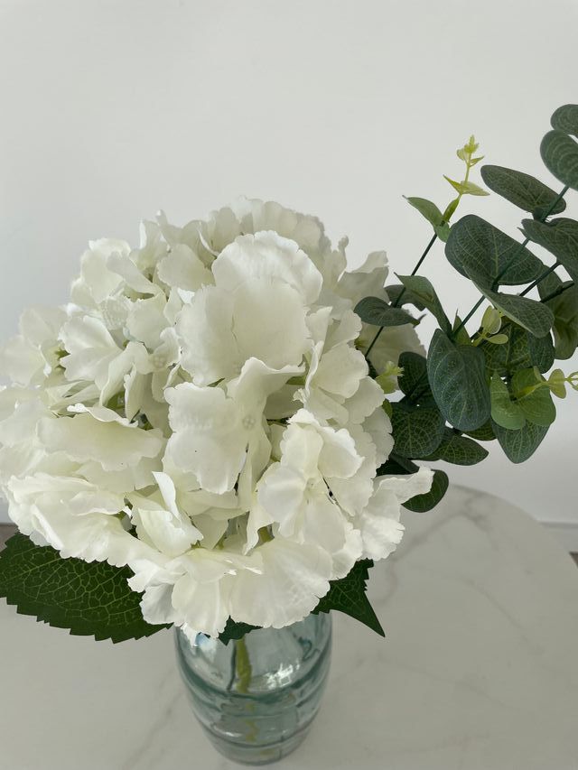 Jarrón de cristal verde  con flores artificiales