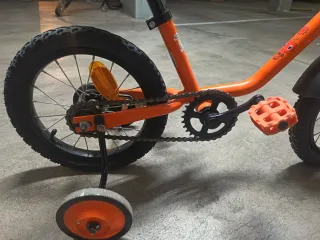 Bicicleta infantil naranja con ruedines