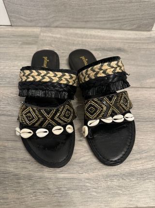 ciabatte nere con conchiglie e pietre