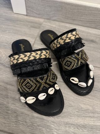 ciabatte nere con conchiglie e pietre