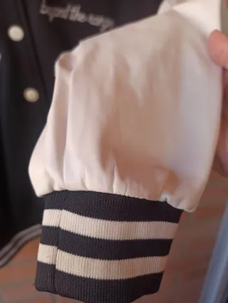 Chaqueta universitaria B negra y crema casi blanca