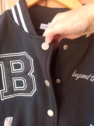 Chaqueta universitaria B negra y crema casi blanca