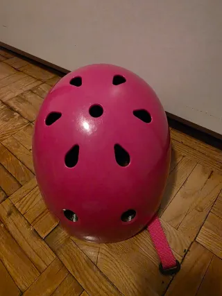Casco rosa para patines y protecciones.