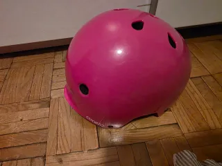 Casco rosa para patines y protecciones.