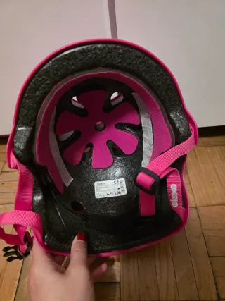 Casco rosa para patines y protecciones.
