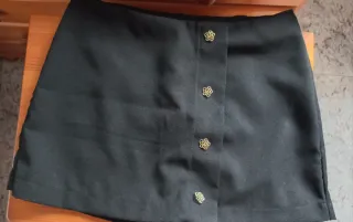Short efeco falda corta negra con botones dorados