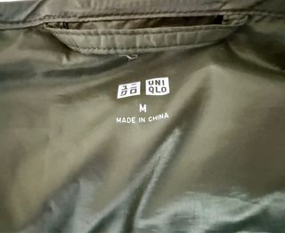 Chaleco Uniqlo de plumas verde abotonado.