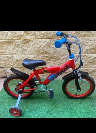 Bicicleta infantil roja con ruedines