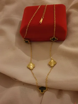 Collar dorado con tréboles negros