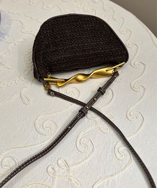 Bolso de mano marrón con asa dorada