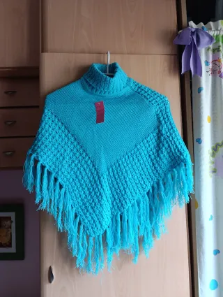 Poncho azul con cuello alto y flecos
