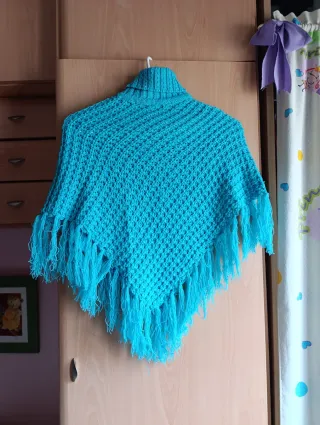 Poncho azul con cuello alto y flecos