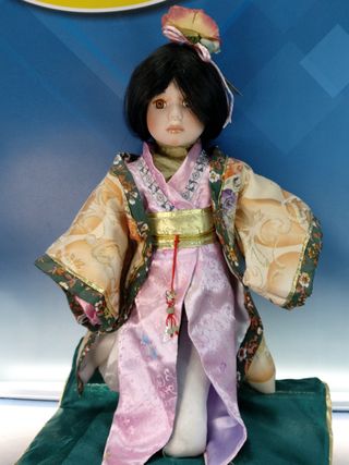 Hana. Bambola di porcellana seduta su cuscino. Abito giapponese, Kimono.