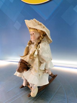 Esther. Bambola di porcellana seduta su un'altalena, cavallo di legno.