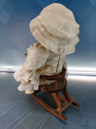 Esther. Bambola di porcellana seduta su un'altalena, cavallo di legno.