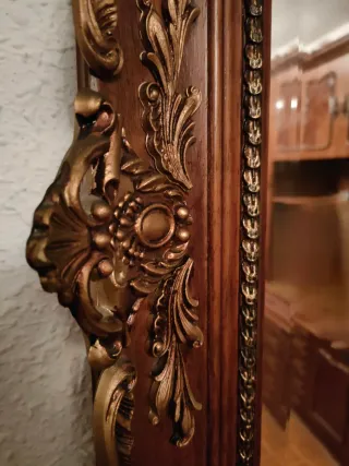 Espejo de madera con marco decorado.