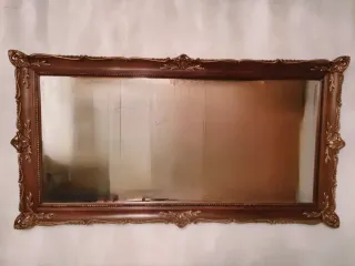 Espejo de madera con marco decorado.