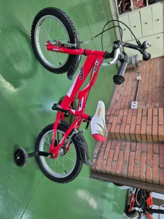 Bicicleta infantil roja con ruedines