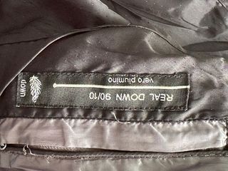 Abrigo plumífero gris con capucha y pelo natural