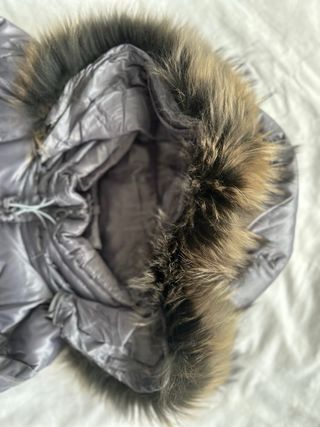 Abrigo plumífero gris con capucha y pelo natural