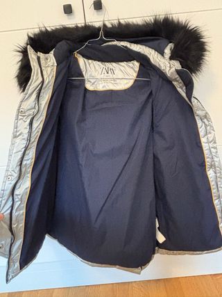 Plumífero plateado con capucha y pelo