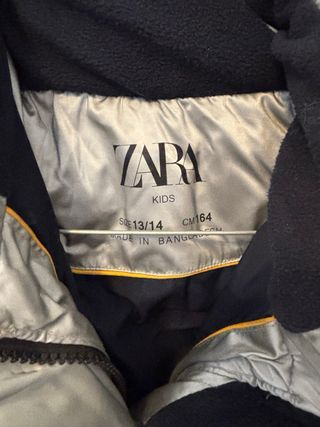 Plumífero plateado con capucha y pelo