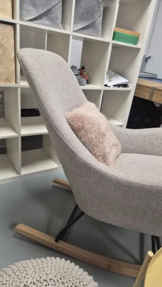 Poltrona a dondolo beige con cuscino rosa