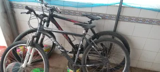 Bicicleta BMX plateada y dos bicicletas de 26 pulg