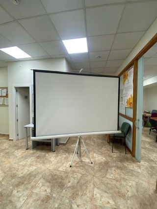 Pantalla de proyector grande con trípode.
