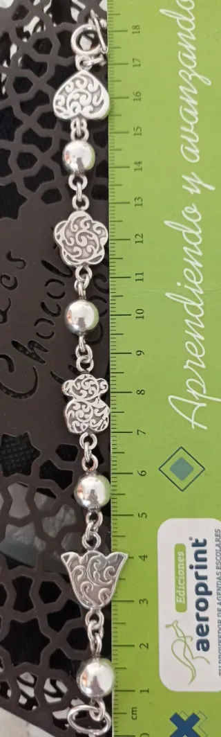 Pulsera de bolas y elaborados adornos.
