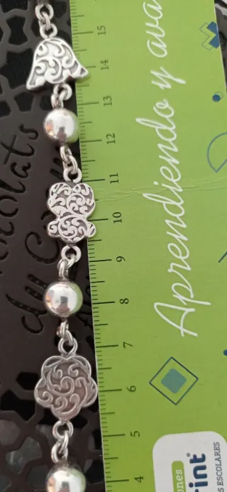 Pulsera de bolas y elaborados adornos.