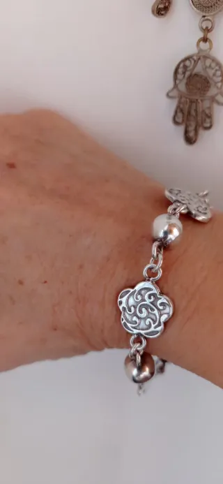 Pulsera de bolas y elaborados adornos.