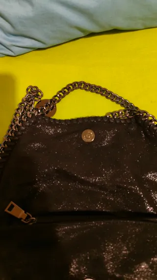 Bolso negro con cadena plateada es un poco brillan