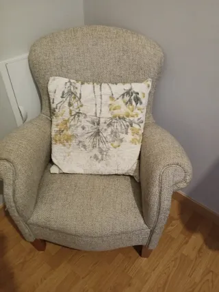 Sofá individual beige con cojín