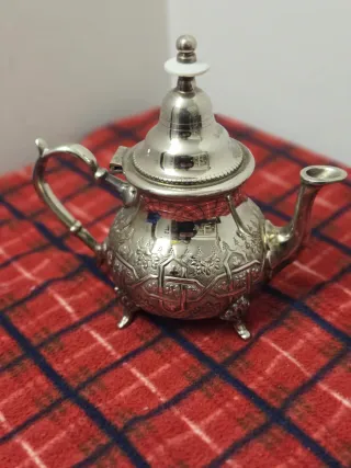 Tetera de metal plateado con detalles