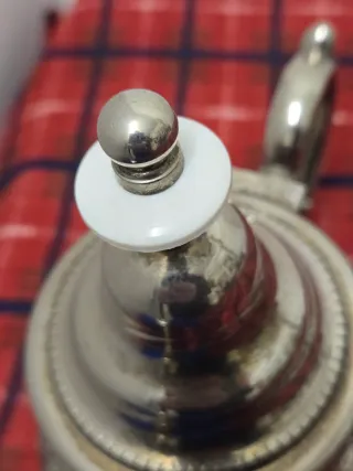 Tetera de metal plateado con detalles