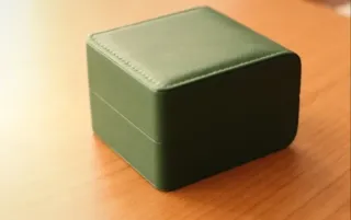 Caja para reloj verde y beige.