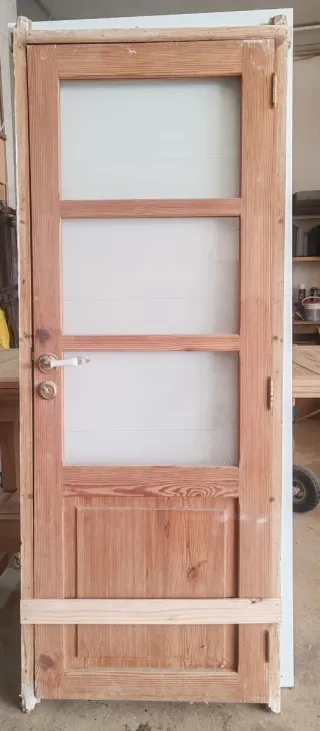 Puerta de madera maciza con marco y manivela