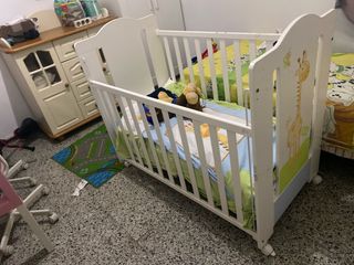 Cuna blanca con jirafa