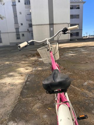 Bicicleta rosa estilo cruiser con cesta